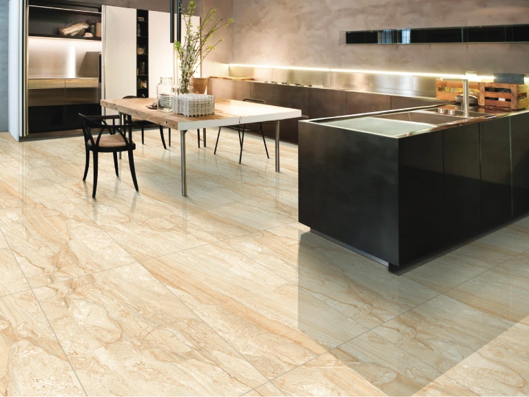Modern kitchen with sleek black cabinets, a large marble island, and a wooden dining table. The floor showcases light, polished stone tiles reminiscent of a gently flowing stream. Decorative plants adorn the table, and the space is well-lit with recessed lighting.